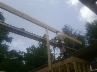 Carpenter setting a ridge beam over a new addition frame — Ice Dam Removal by Roofing Brothers in Westminster