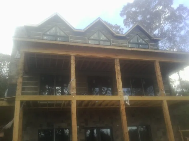 Dormers and porch framing on a large log home under construction — Roof Coating work by our crew in Westminster